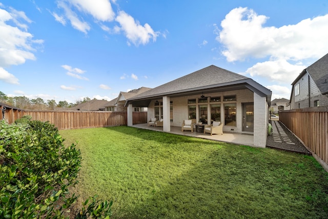 back of property with a yard and a patio