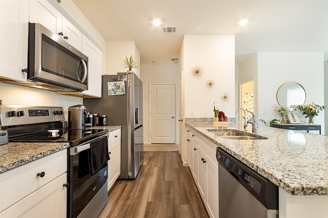 kitchen featuring white cabinetry, sink, stainless steel appliances, light stone countertops, and dark wood-type flooring