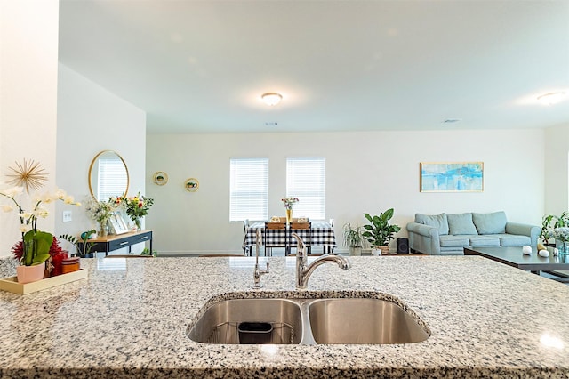 kitchen featuring light stone countertops and sink