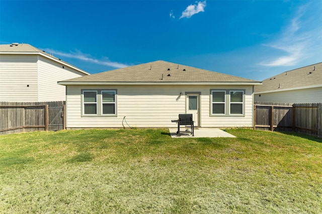 rear view of house featuring a yard and a patio