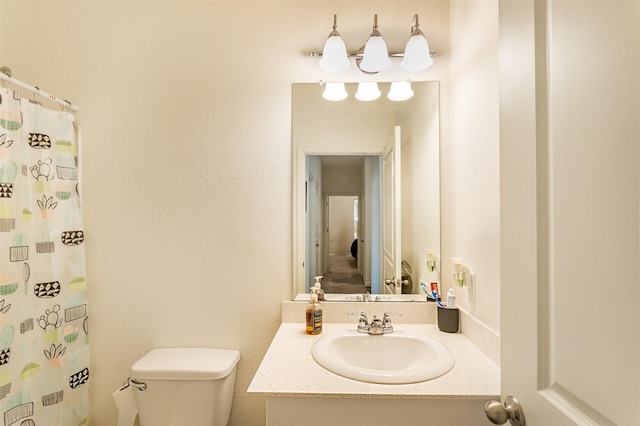 bathroom with vanity, curtained shower, and toilet