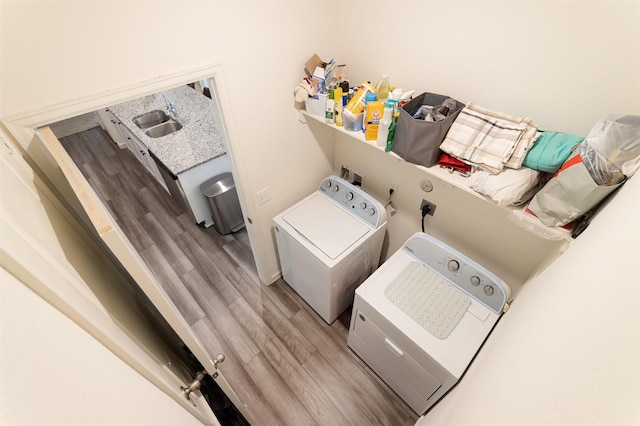 laundry room featuring sink, hardwood / wood-style flooring, and independent washer and dryer