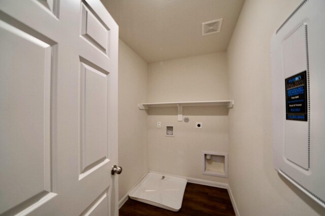 washroom featuring dark wood-type flooring, gas dryer hookup, electric panel, hookup for a washing machine, and hookup for an electric dryer