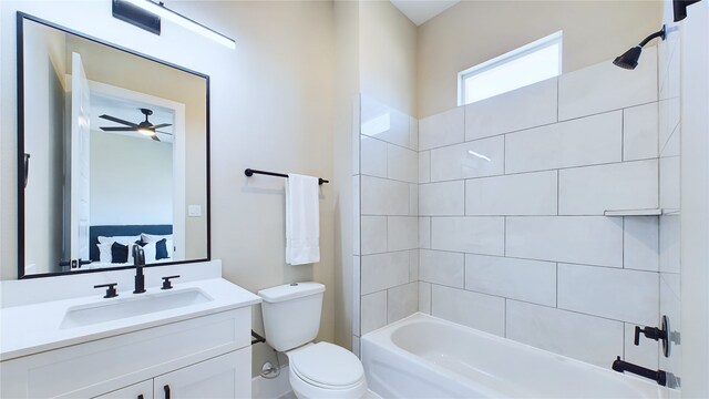 full bathroom featuring vanity, ceiling fan, toilet, and tiled shower / bath