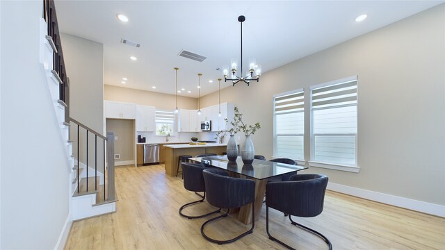 dining room with a chandelier and light wood-type flooring