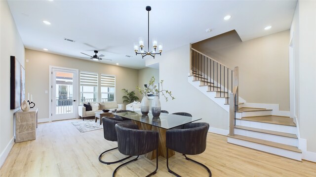 dining area with ceiling fan with notable chandelier and light hardwood / wood-style flooring