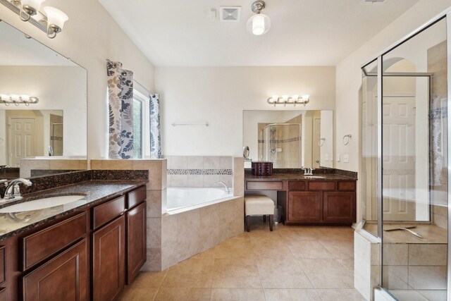 bathroom featuring vanity, shower with separate bathtub, and tile patterned flooring