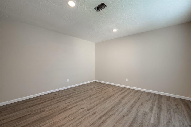 empty room featuring hardwood / wood-style flooring and a textured ceiling