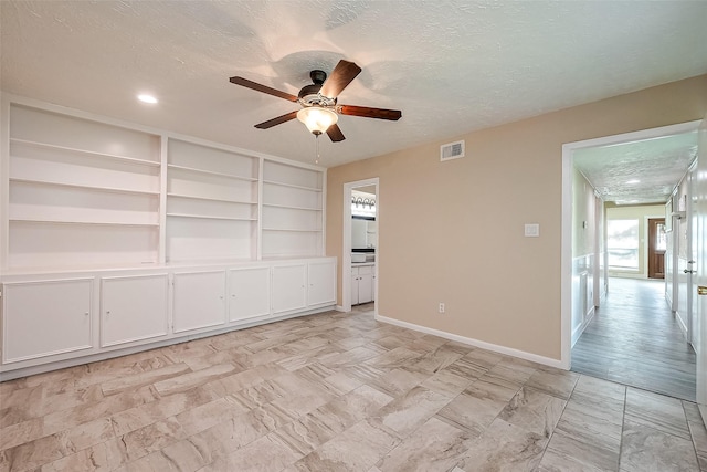 spare room with ceiling fan and a textured ceiling