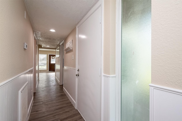 hallway featuring dark hardwood / wood-style flooring and a textured ceiling