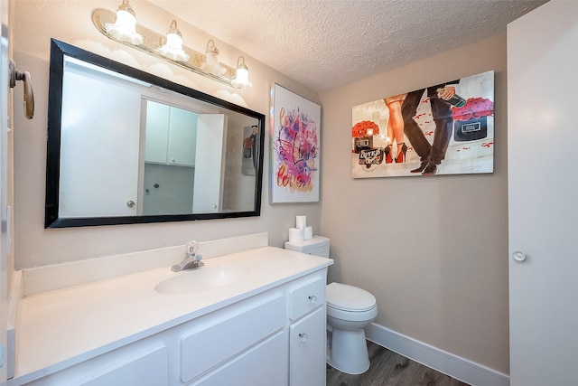 bathroom with vanity, hardwood / wood-style floors, a textured ceiling, and toilet