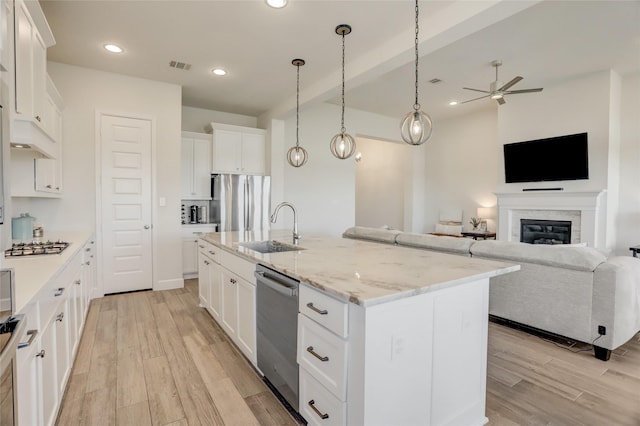 kitchen featuring visible vents, appliances with stainless steel finishes, open floor plan, and a sink