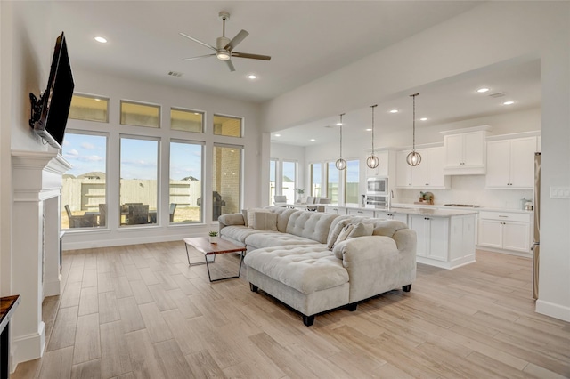 living room featuring light hardwood / wood-style flooring and ceiling fan