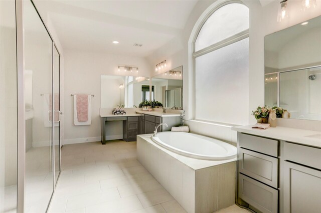 bathroom with vanity, tile patterned flooring, and plus walk in shower