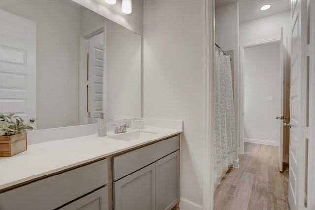 bathroom featuring wood finished floors, vanity, and baseboards