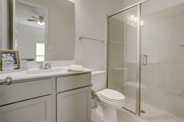 bathroom featuring vanity, ceiling fan, toilet, and walk in shower