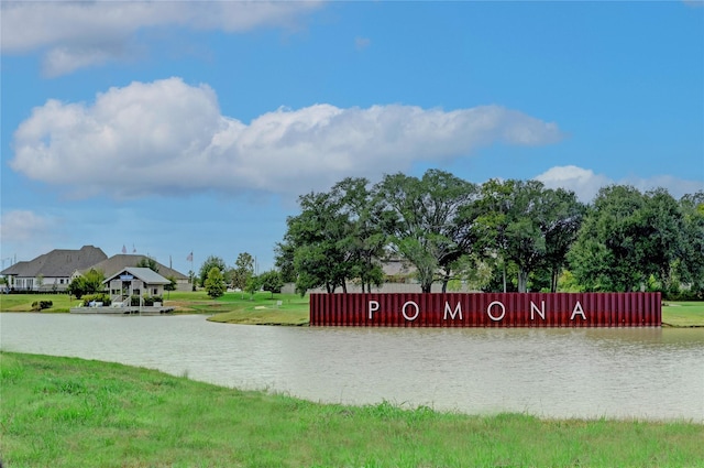 surrounding community featuring a water view and a lawn