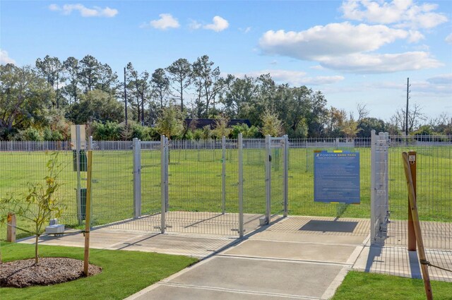 view of home's community featuring a yard, fence, and a gate