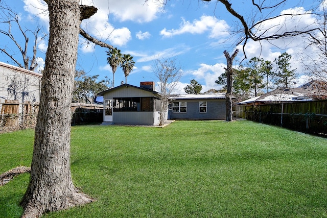 rear view of property with a sunroom and a yard