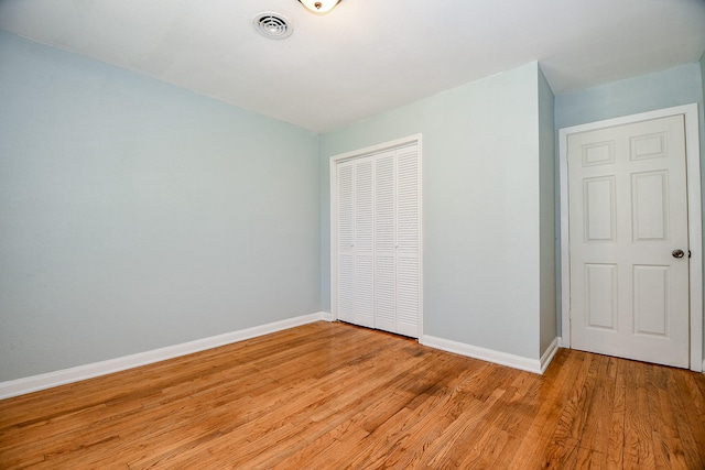 unfurnished bedroom with a closet and light hardwood / wood-style flooring