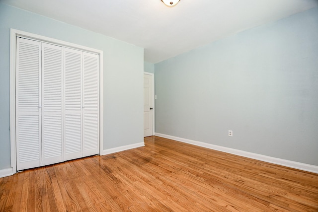 unfurnished bedroom featuring light hardwood / wood-style floors and a closet