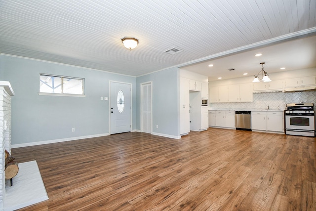 unfurnished living room featuring ornamental molding, sink, hardwood / wood-style floors, and an inviting chandelier