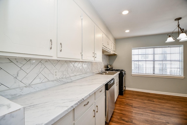 kitchen featuring appliances with stainless steel finishes, pendant lighting, tasteful backsplash, white cabinetry, and sink