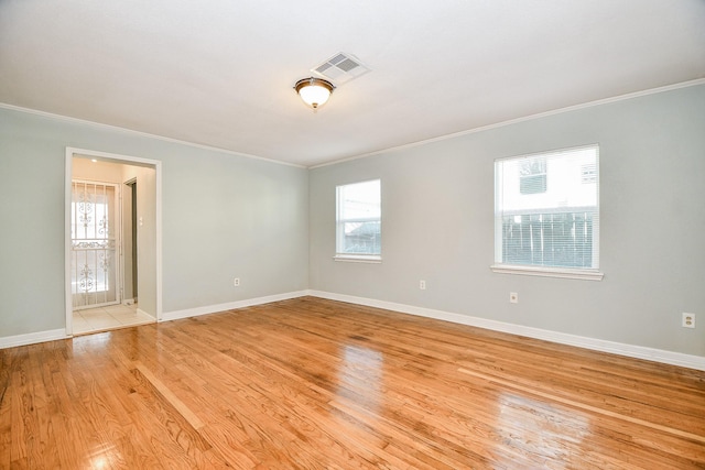 empty room with light hardwood / wood-style flooring and ornamental molding