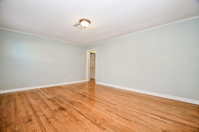 empty room featuring crown molding and light wood-type flooring