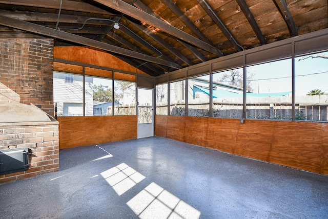 unfurnished sunroom featuring lofted ceiling with beams and wooden ceiling