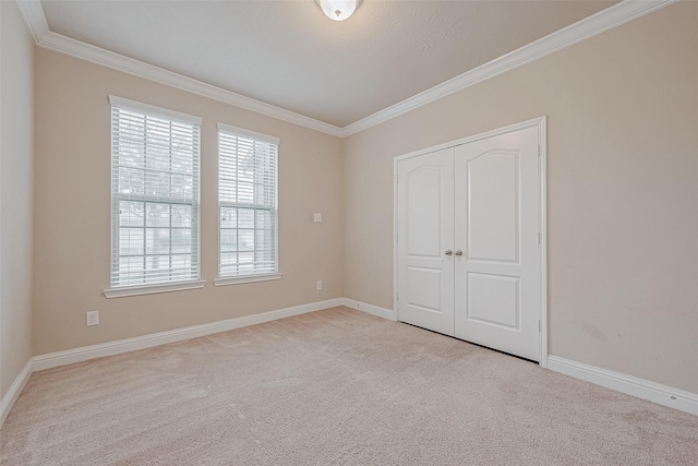 unfurnished bedroom with ornamental molding, light colored carpet, and a closet