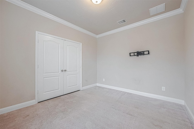 unfurnished bedroom featuring crown molding, a closet, and carpet