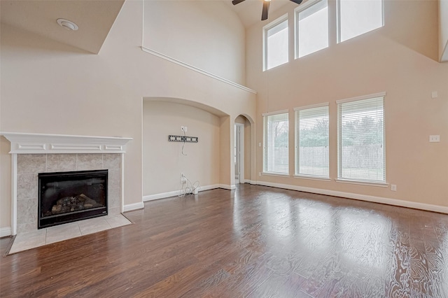 unfurnished living room with ceiling fan, a fireplace, and light wood-type flooring