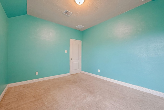 unfurnished room featuring carpet flooring and a textured ceiling