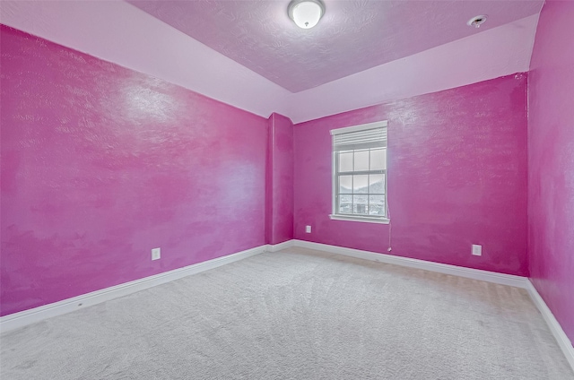 empty room with a textured ceiling and carpet flooring