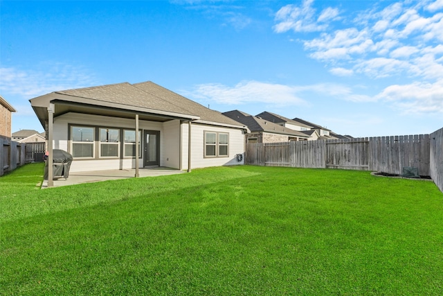 back of house with a patio and a lawn