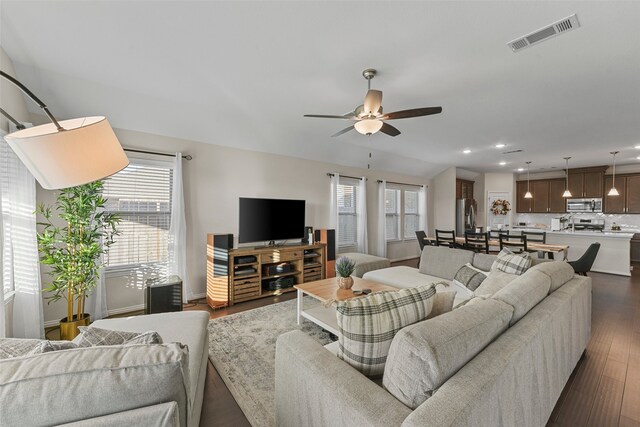 living room with dark wood-type flooring and ceiling fan