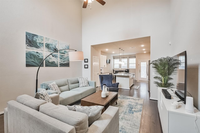 living room featuring ceiling fan, dark hardwood / wood-style flooring, sink, and a high ceiling