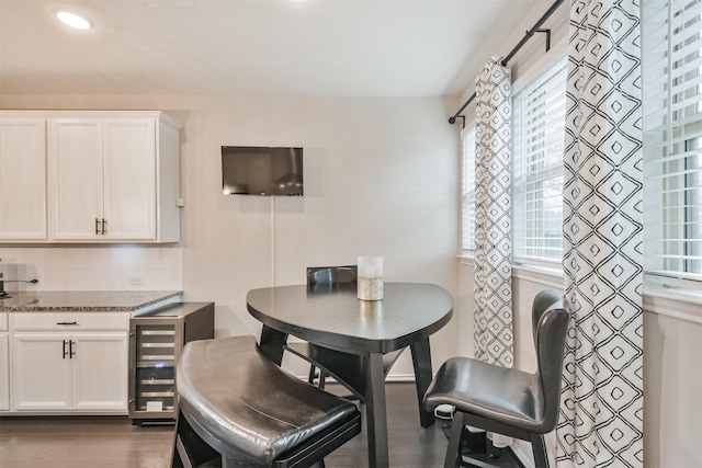 dining space with wine cooler and dark wood-type flooring