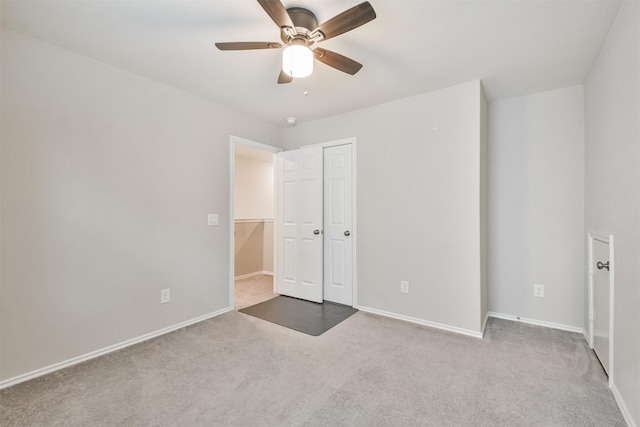 unfurnished bedroom featuring light carpet, ceiling fan, and a closet