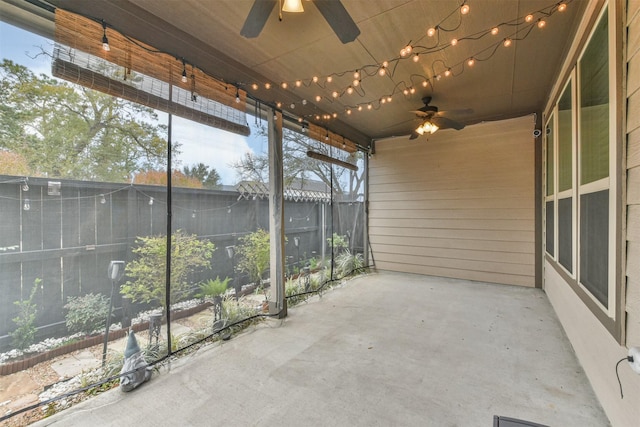 unfurnished sunroom featuring ceiling fan