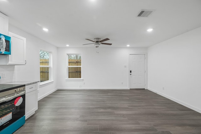 interior space featuring light stone counters, dark hardwood / wood-style floors, white cabinets, and stainless steel electric range oven