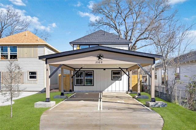 view of front of property with board and batten siding, a front yard, driveway, and fence