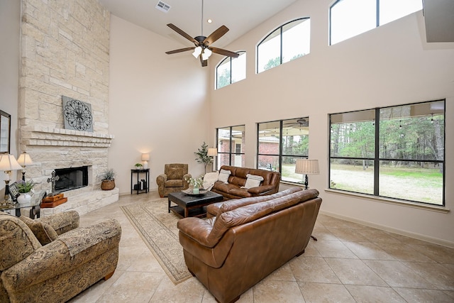 tiled living room featuring ceiling fan and a fireplace