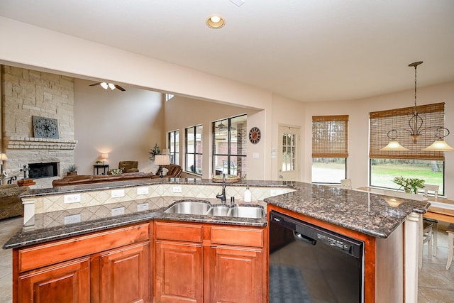 kitchen with sink, decorative backsplash, a fireplace, and black dishwasher