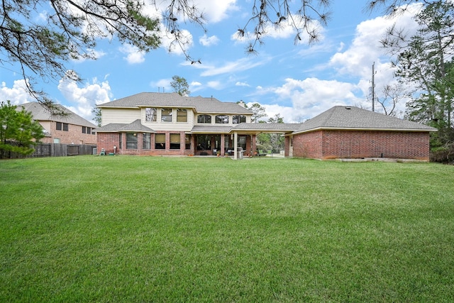 rear view of property featuring a lawn