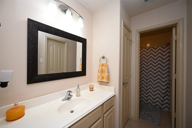 bathroom with vanity and a shower