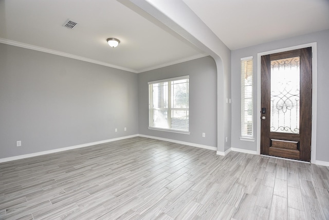 foyer entrance with crown molding and light hardwood / wood-style flooring