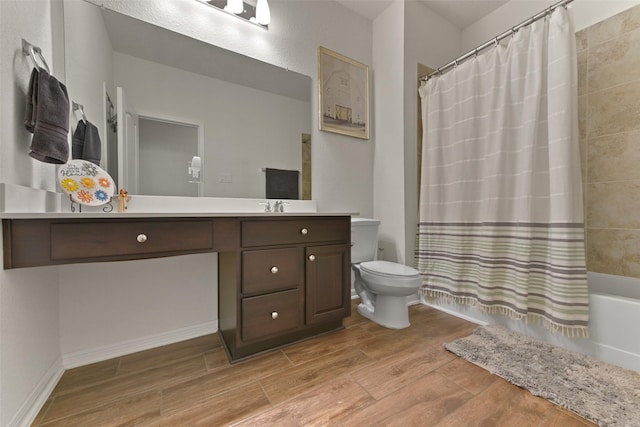 full bathroom with hardwood / wood-style flooring, vanity, shower / bathtub combination with curtain, and toilet