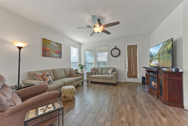 living room featuring hardwood / wood-style floors, a textured ceiling, and ceiling fan